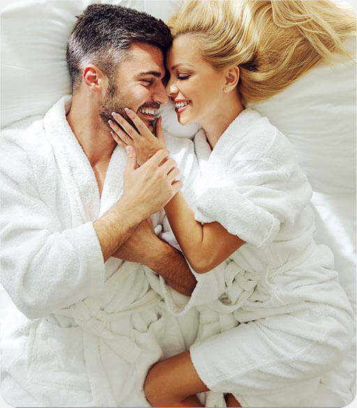 Couple lying in bed smiling